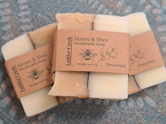 Handmade soap bars with Ladder Creek branding on a textured surface