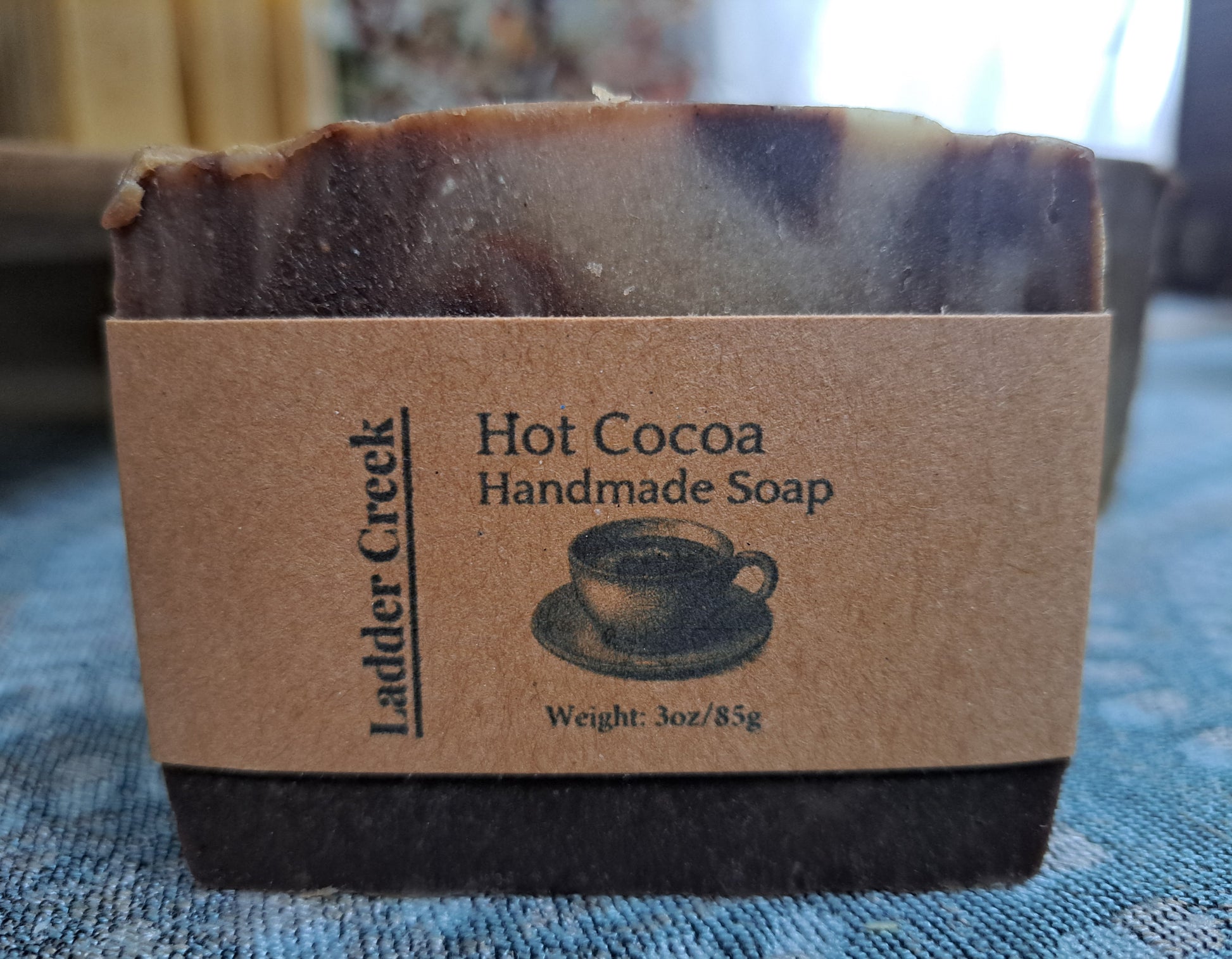 Hot Cocoa handmade soap bar with Ladder Creek branding on a textured surface