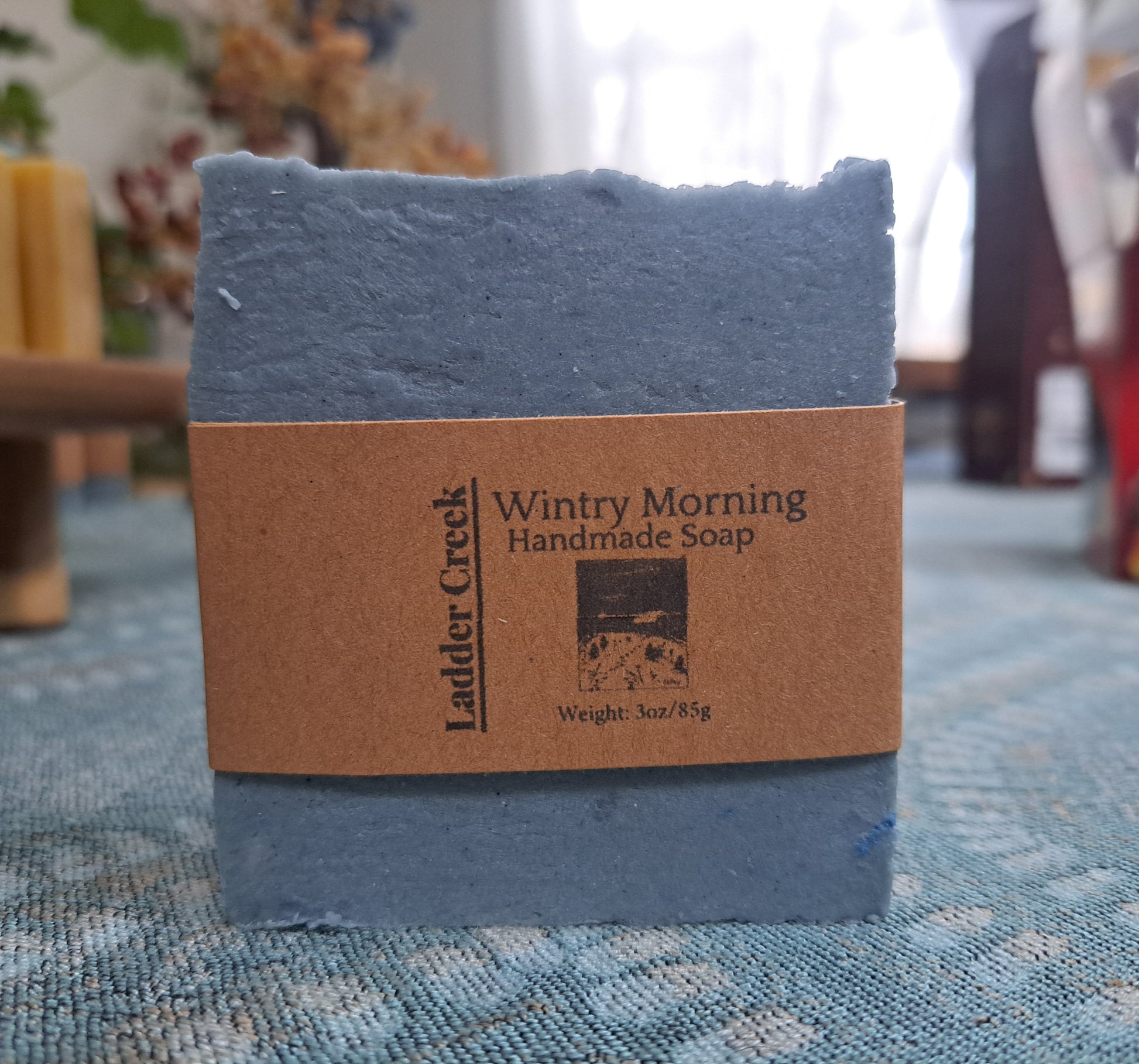 Blue handmade soap bar with a brown label on a textured surface