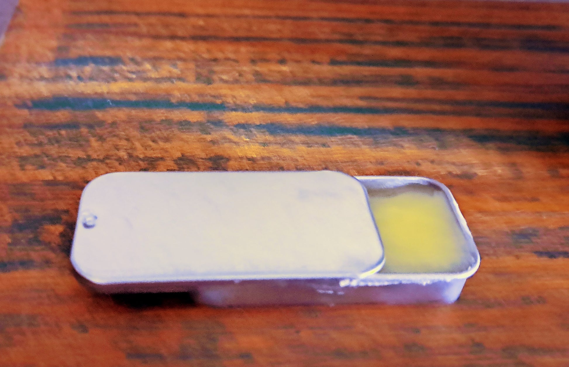 lip balm tin on wooden surface