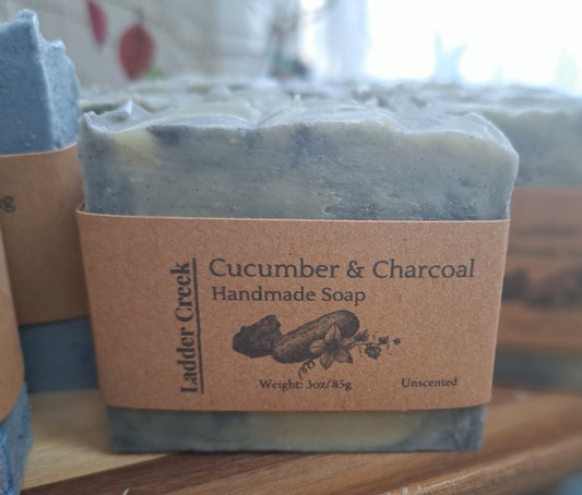 Cucumber & Charcoal handmade soap with a label on a wooden surface